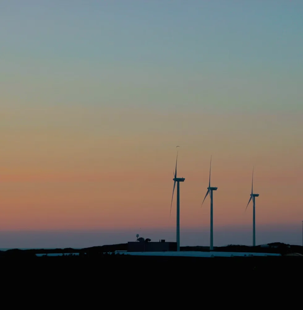Wind turbines at dusk, representing energy-efficient industrial infrastructure